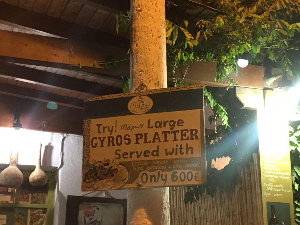 "Enseigne pour un menu plateau de gyros éclairée la nuit."
Alternative translation: "Panneau lumineux nocturne pour un menu plateau de gyros."