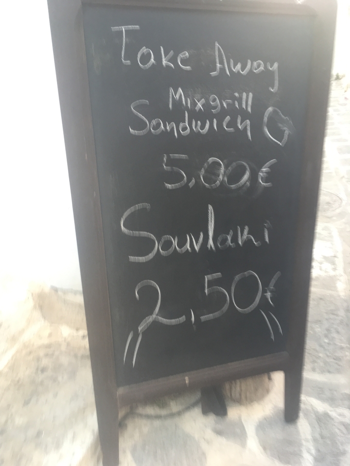 Panneau d'ardoise affichant les prix de la nourriture de rue locale.