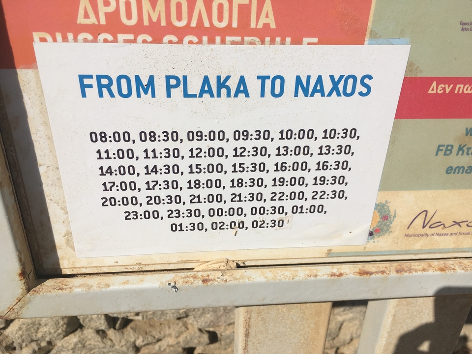 Panneau d'affichage avec les horaires de ferry de Plaka à Naxos.