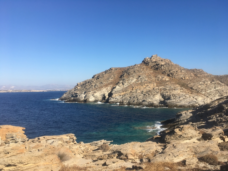 Côte rocheuse escarpée avec mer bleue et ciel dégagé.