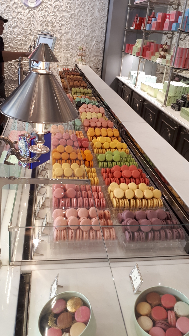 Macarons colorés assortis exposés dans une pâtisserie.