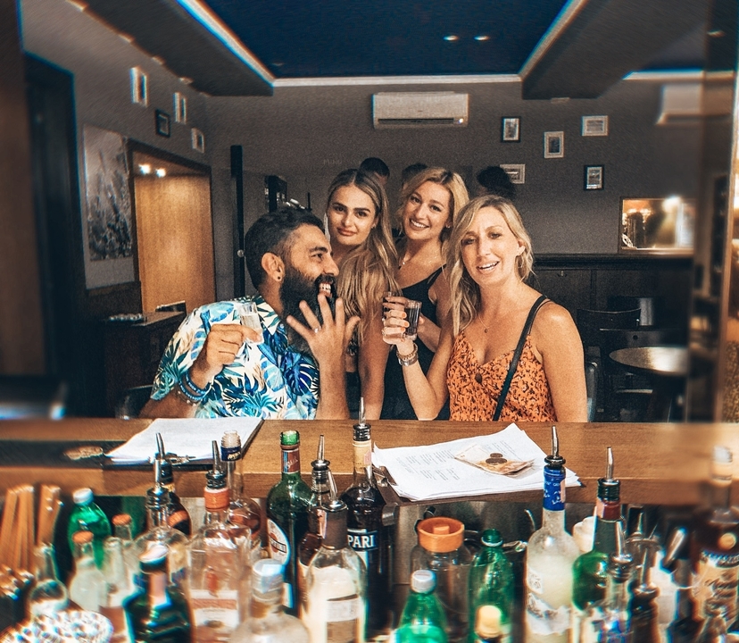 Groupe de personnes savourant des boissons dans un bar animé.