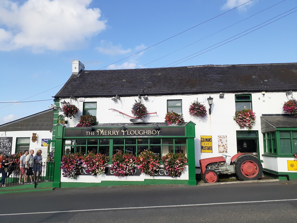 Pub avec des décorations florales et des gens à l'entrée
