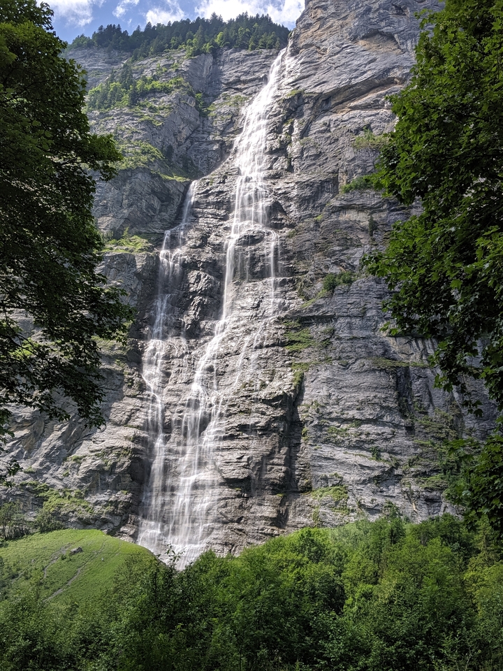 Grande cascade coulant le long d'une surface rocheuse.