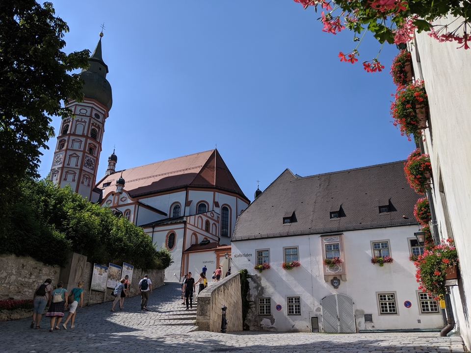 Des gens qui marchent près d'une grande église sur une colline.