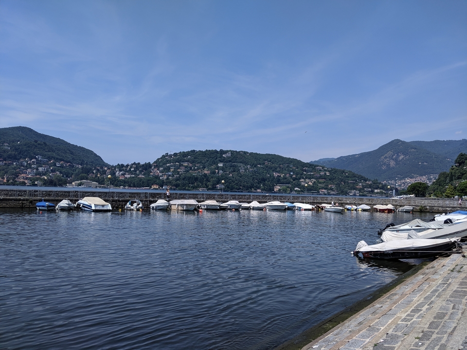 Des bateaux amarrés sur un lac entouré de collines.