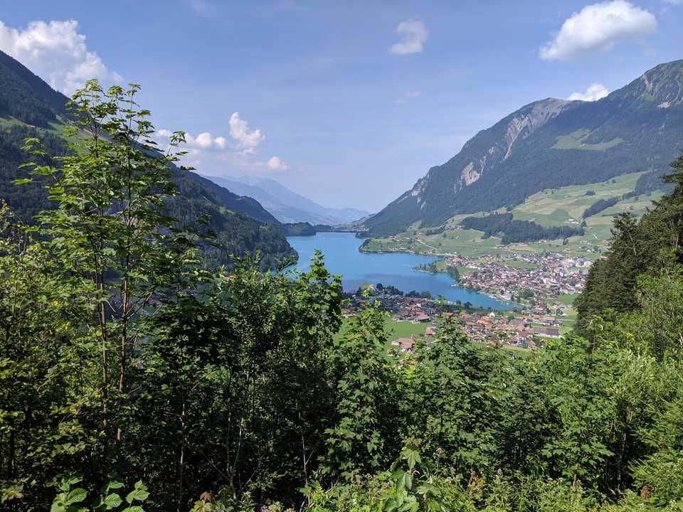 Lac entouré de montagnes et d'un village.