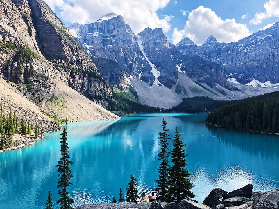 Vue d'un magnifique lac bleu entouré de montagnes.