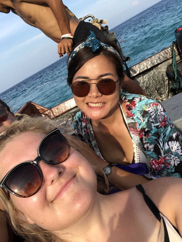 Selfie de groupe sur un bateau avec l'océan en arrière-plan.