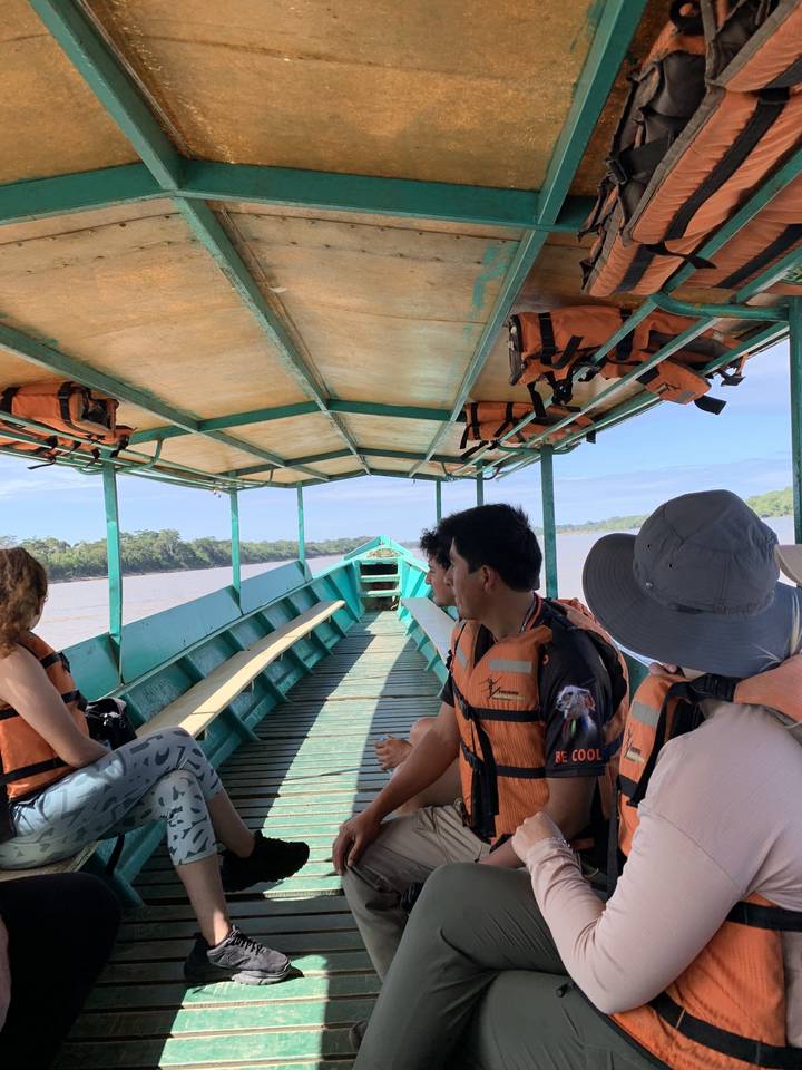 Des gens dans un bateau sur une rivière portant des gilets de sauvetage.