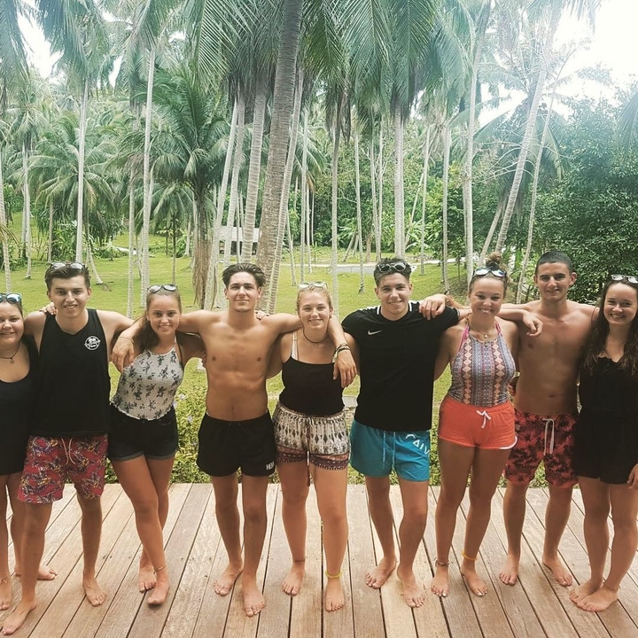 Group of friends posing in a tropical garden.