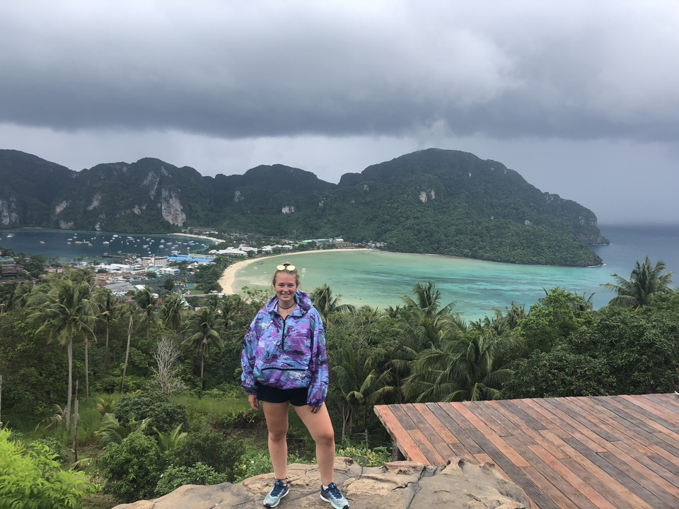 Traveler posing at a scenic viewpoint overlooking a bay.