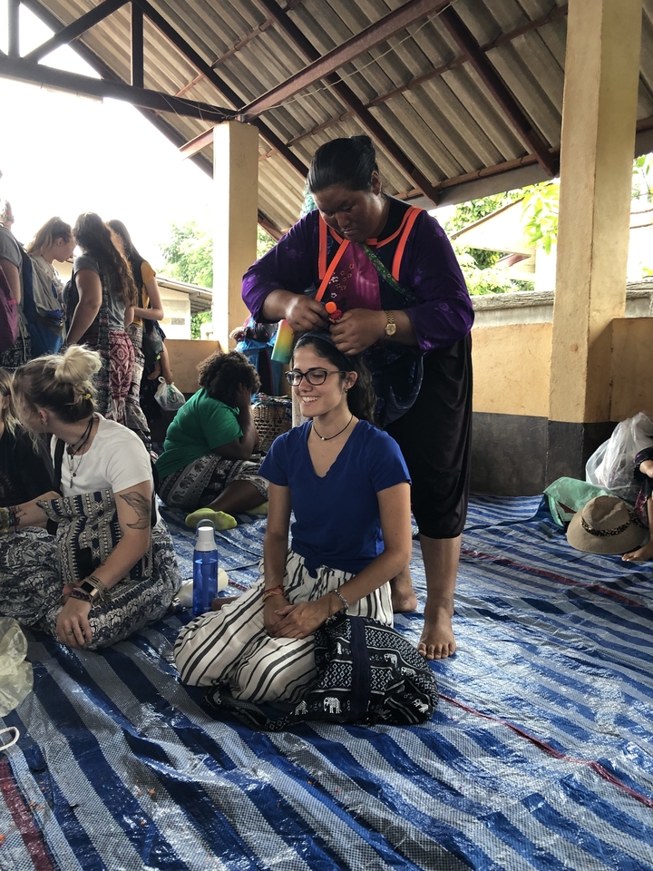 Groupe de femmes assises à l'intérieur, recevant un service de tressage de cheveux.