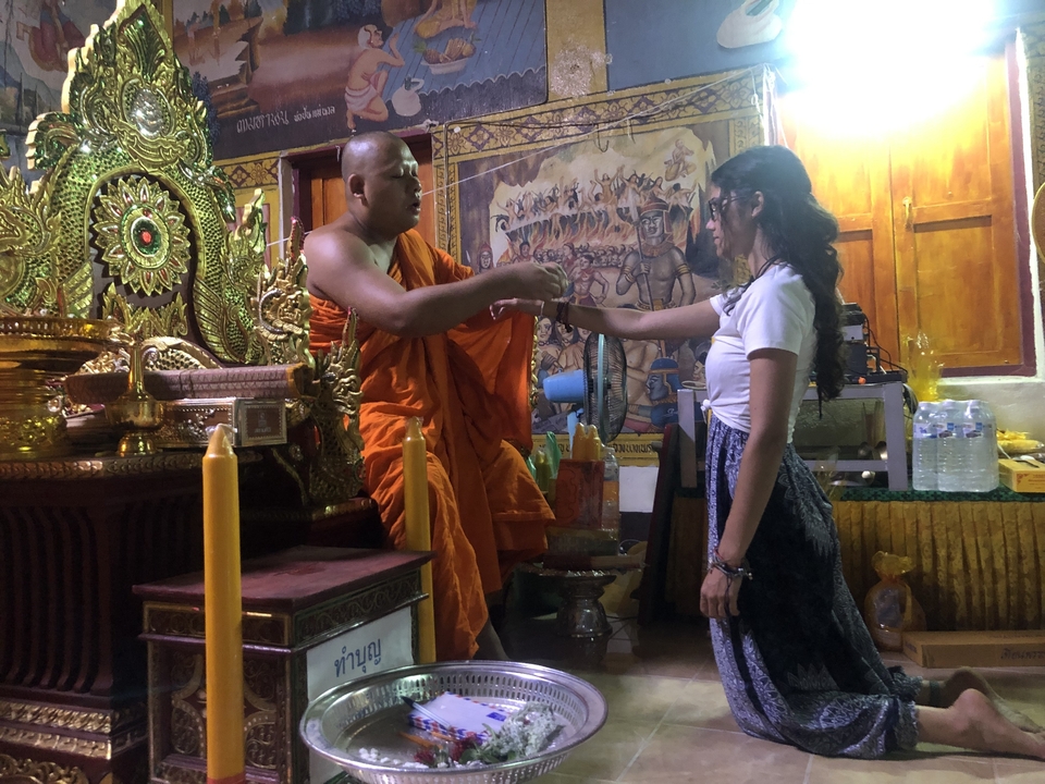 Moine donnant une bénédiction à une femme à l'intérieur d'un temple.