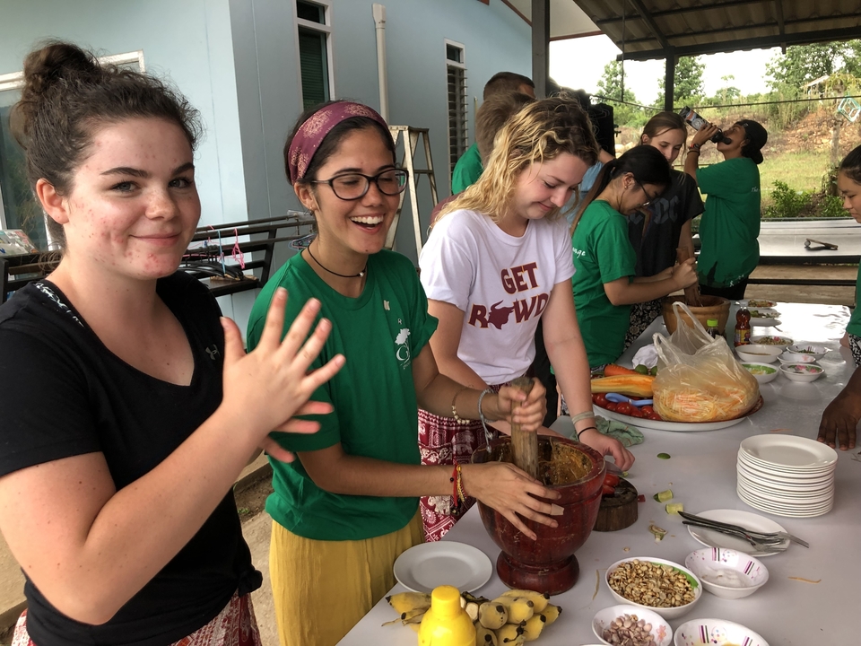 Groupe de personnes préparant de la nourriture ensemble en plein air.