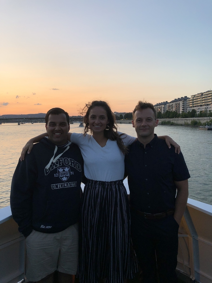 Trois amis qui posent ensemble avec un pont et de l'eau en arrière-plan.