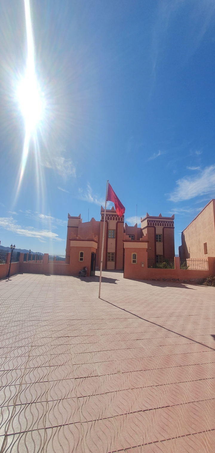 Bâtiment traditionnel avec un drapeau marocain à l'extérieur.