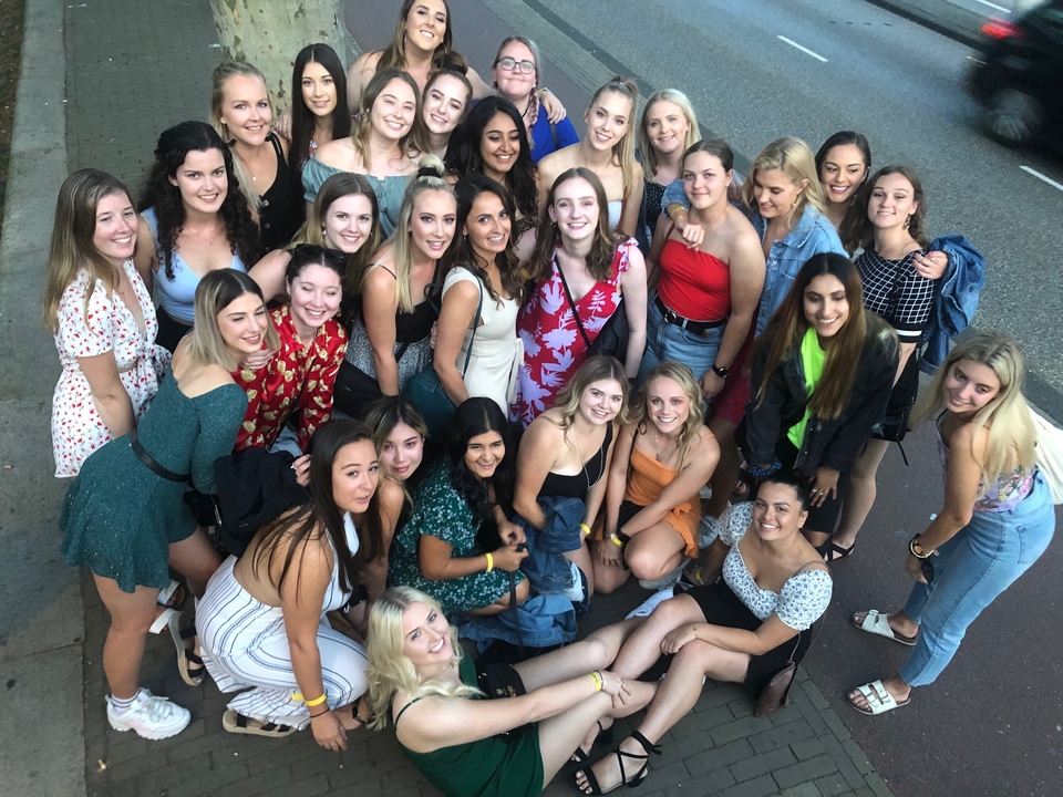 Un grand groupe de personnes posant en plein air.