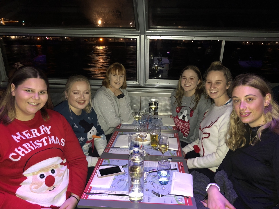 Groupe de personnes partageant un repas ensemble sur un bateau.