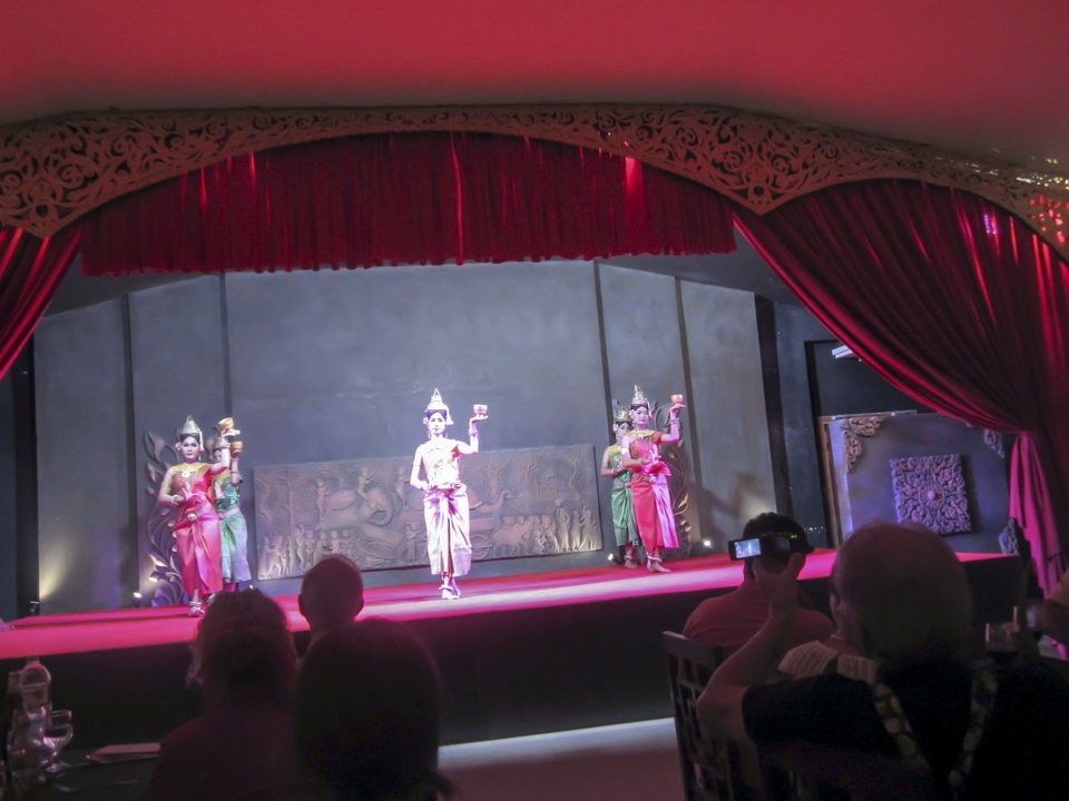 Spectacle de danse traditionnelle sur une scène avec un public.