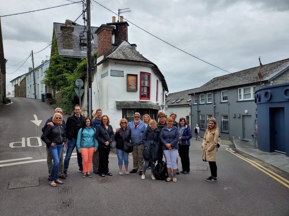 Un groupe de personnes posant dans une rue pittoresque avec une architecture traditionnelle.