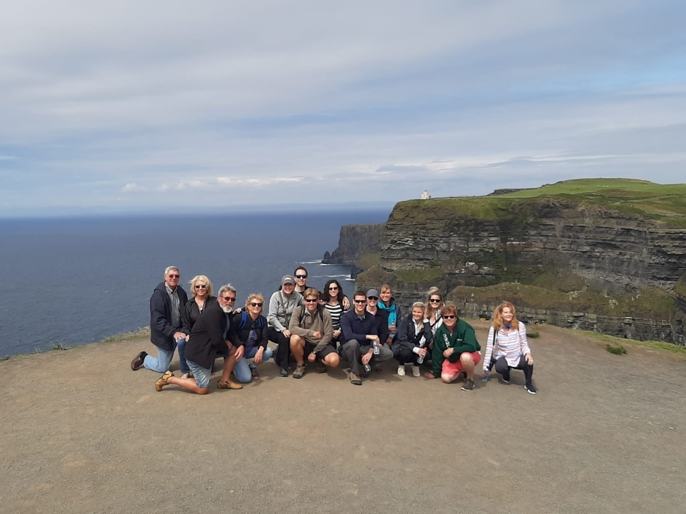 Un groupe de personnes devant les falaises de Moher.