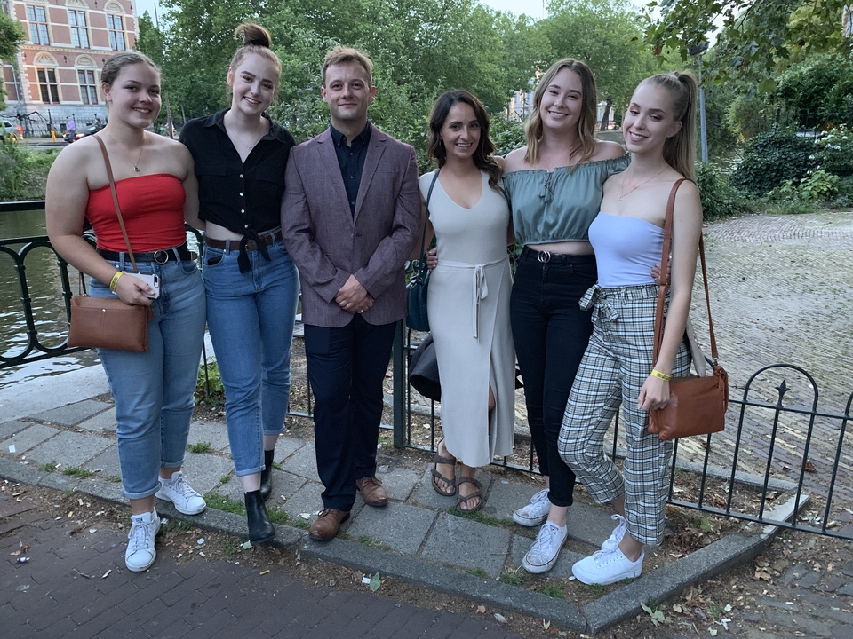 Groupe de personnes posant au bord de l'eau dans une ville.