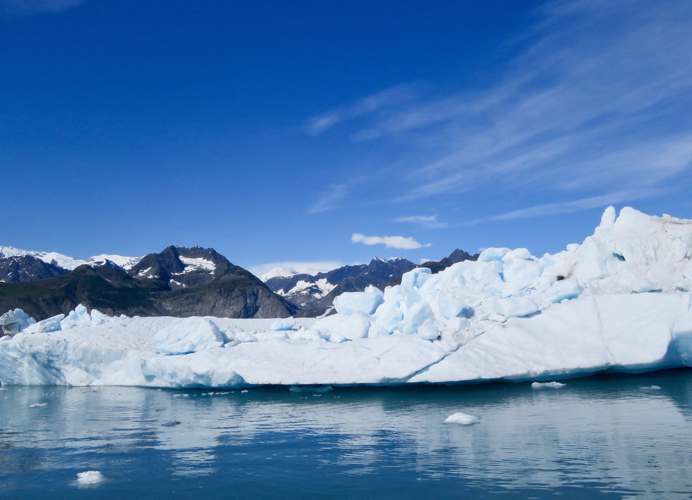 Glacier et montagnes se reflétant dans un plan d'eau.