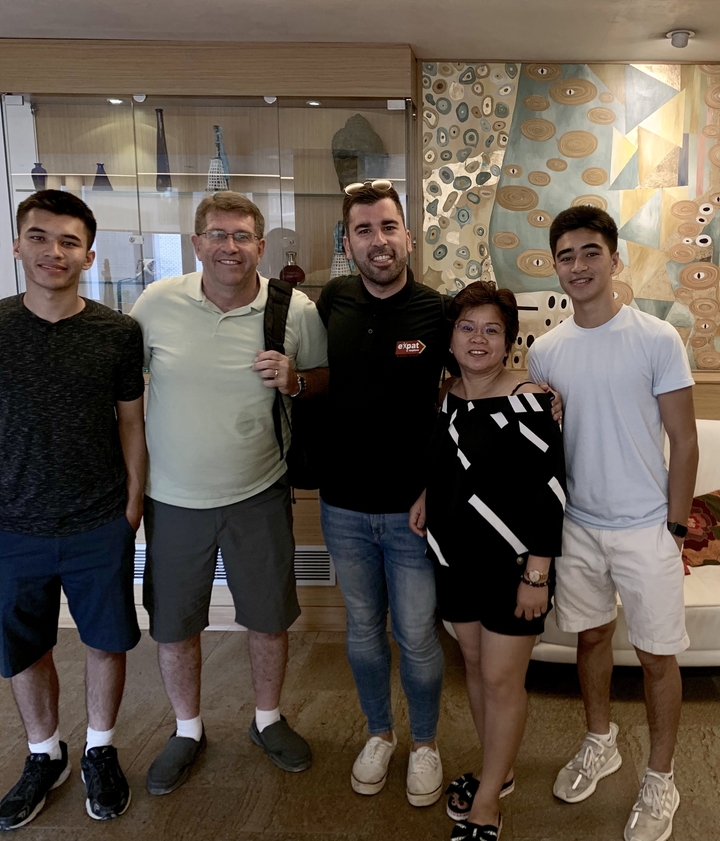 Groupe de personnes posant à l'intérieur avec des œuvres d'art en arrière-plan.