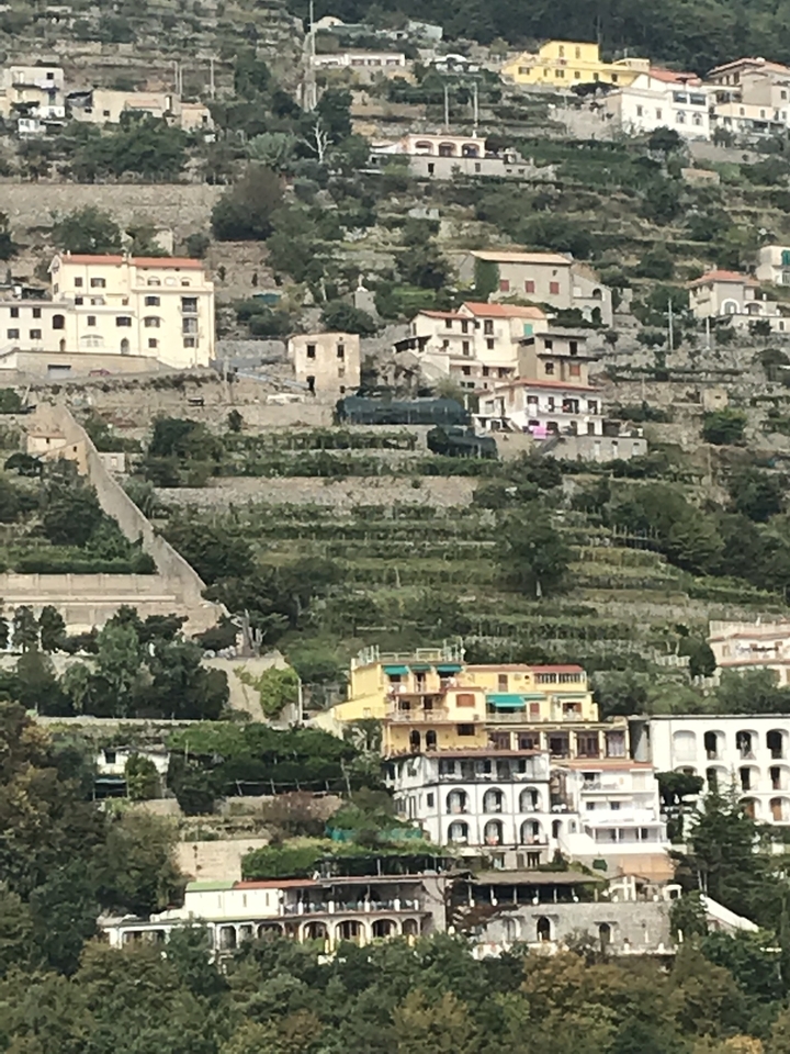 Colline en terrasses avec bâtiments et végétation.