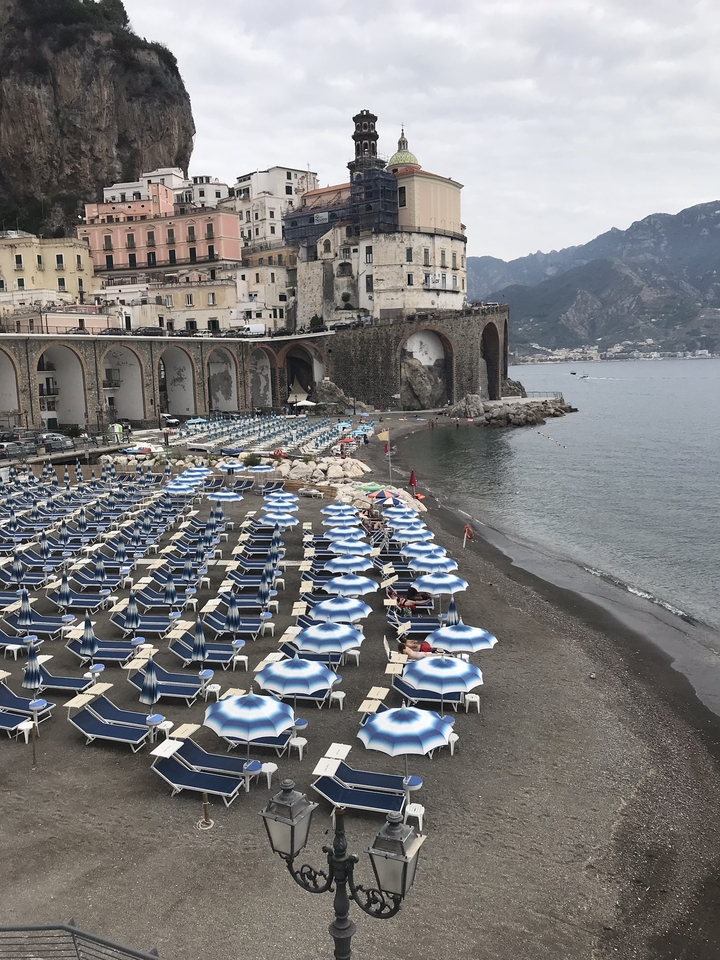 Plage avec plusieurs transats et parasols au bord de la mer.