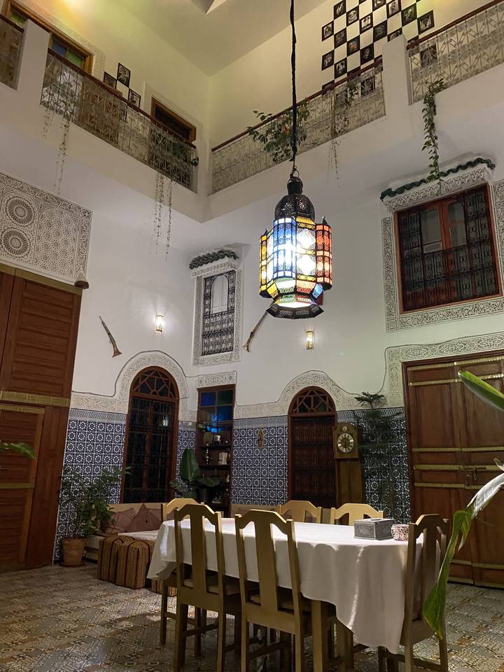 Intérieur vivement éclairé avec un décor orné et un coin repas.