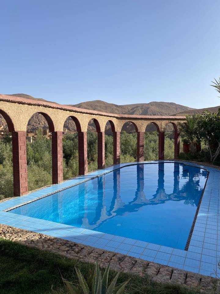 Piscine avec toile de fond montagneuse et arches.