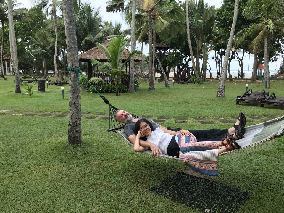 Couple se détendant dans un hamac dans un jardin.