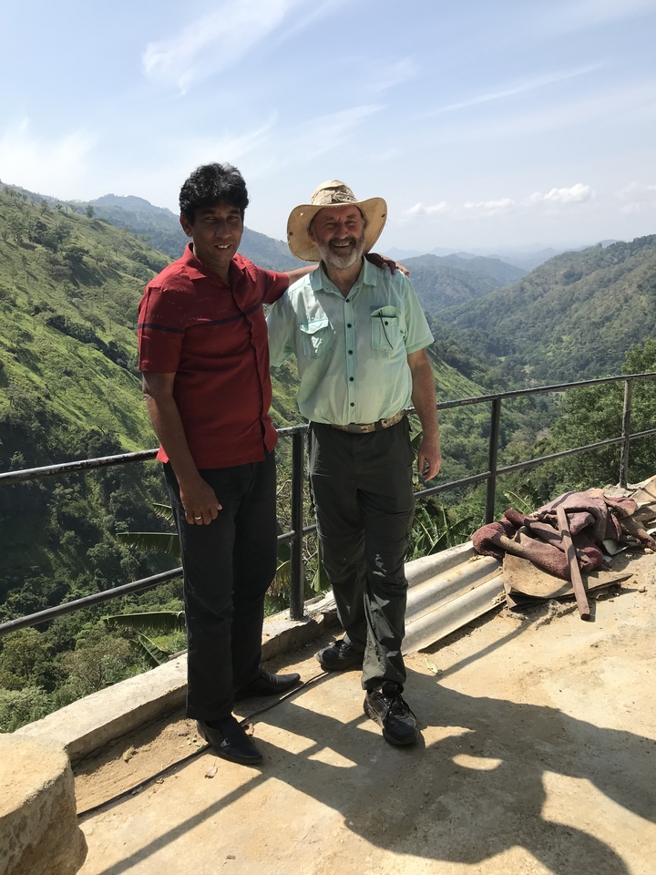Deux personnes debout avec un arrière-plan vallonné.