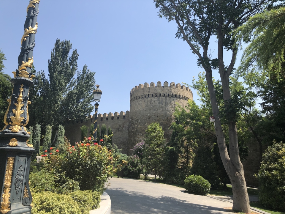 Une forteresse de pierre entourée d'arbres dans un cadre de parc.