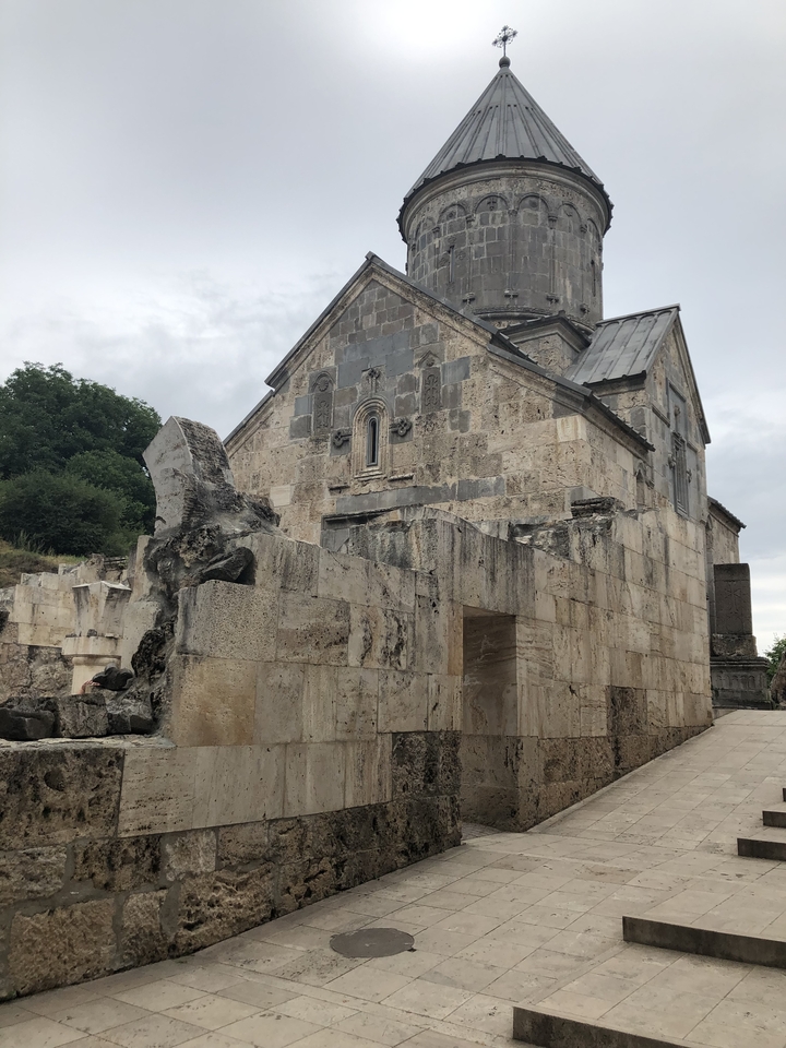 Église en pierre avec des ruines d'un mur d'enceinte.