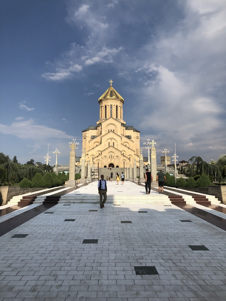 Grande cathédrale avec des touristes devant.