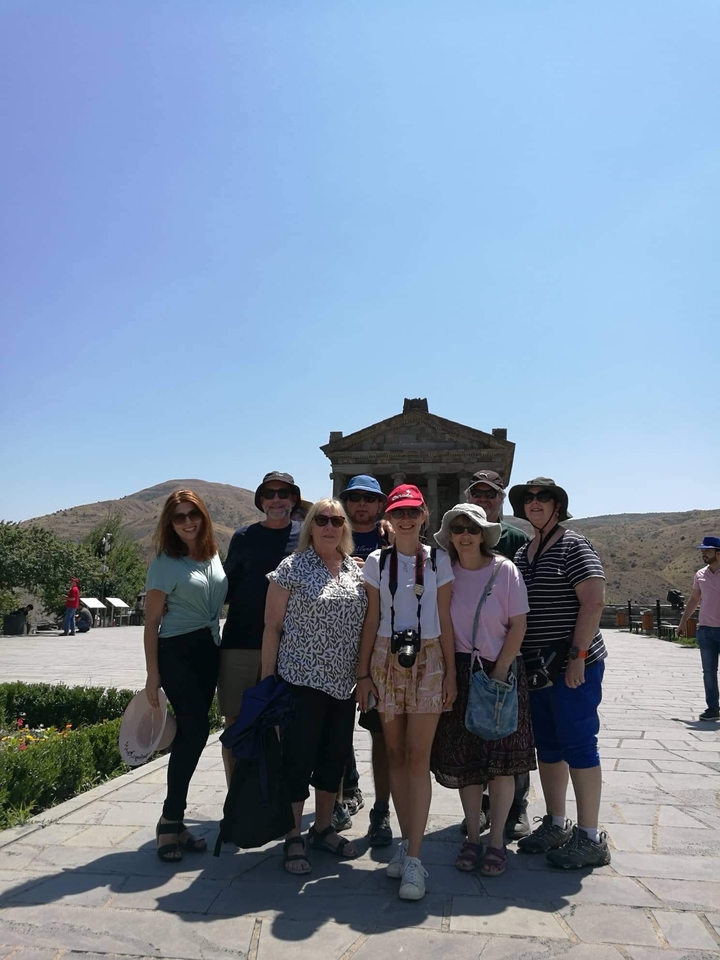 Groupe de touristes devant un temple historique.
