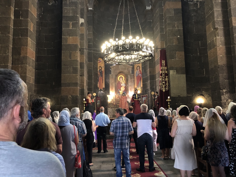 Intérieur d'une église avec des personnes assistant à un service religieux.