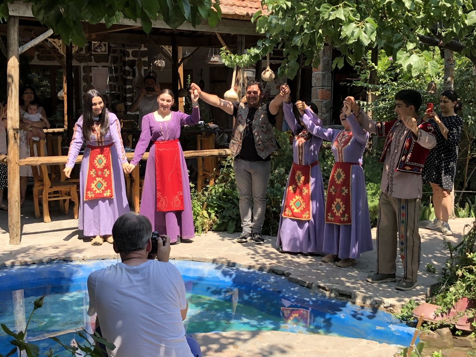 Groupe de personnes en tenue de danse traditionnelle dans un jardin.