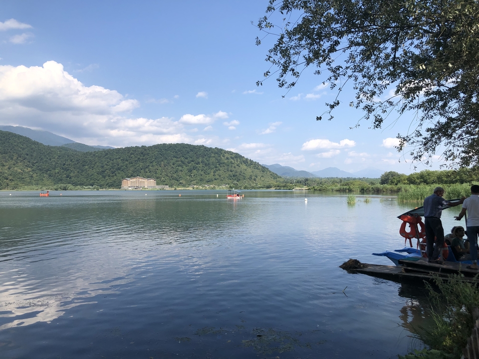 Lac avec des montagnes en arrière-plan et un bateau sur l'eau.