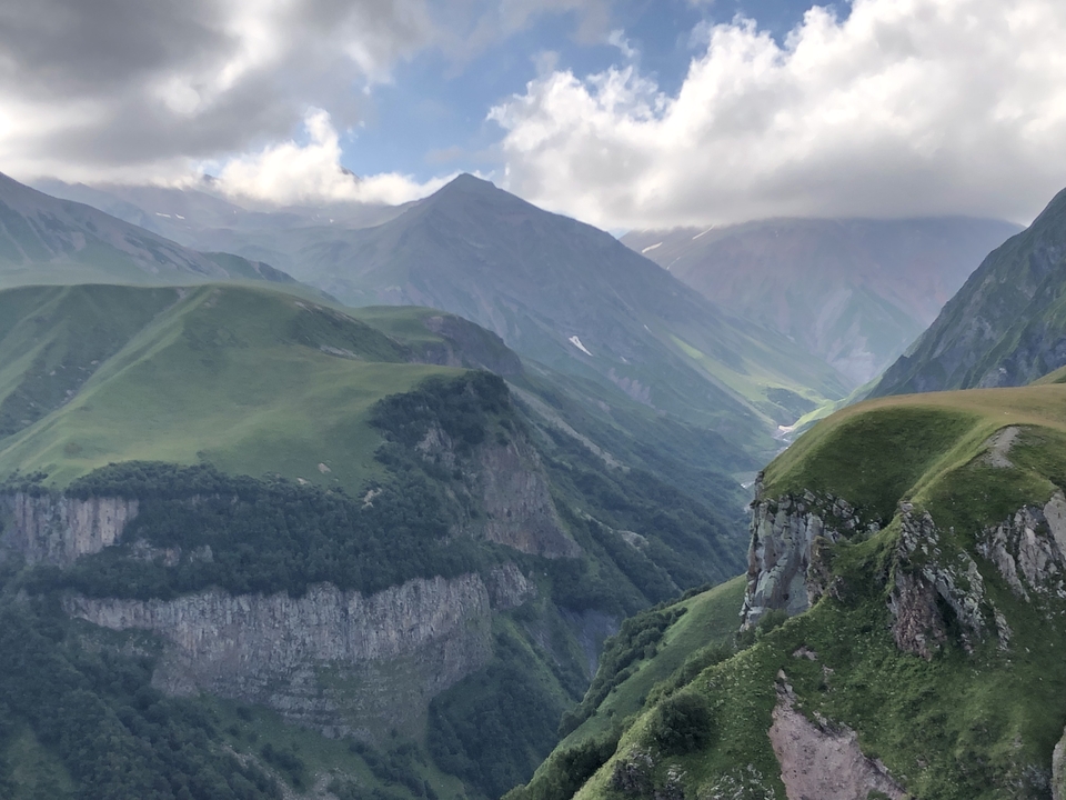 Vue panoramique de montagnes et vallées verdoyantes.