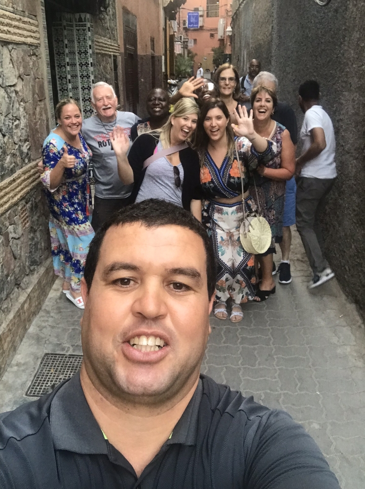 Groupe de personnes prenant un selfie dans une ruelle étroite.