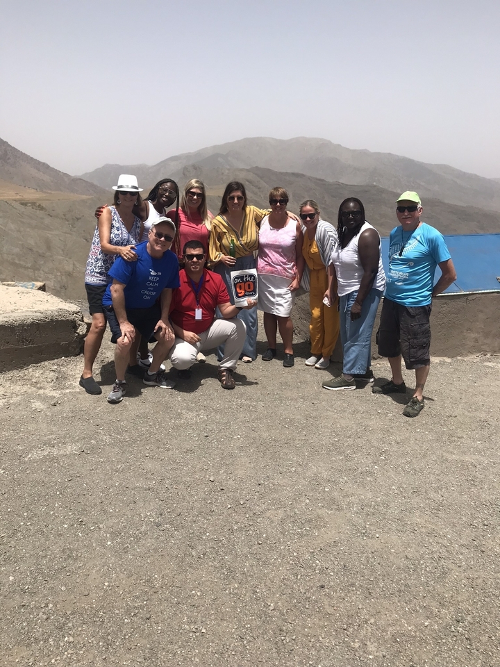 Groupe de touristes posant pour une photo dans un environnement désertique.