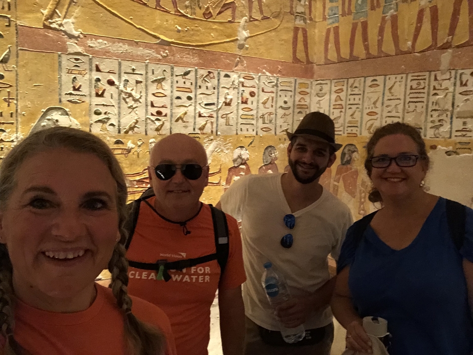 Groupe de personnes posant devant des œuvres d'art de l'Égypte antique.