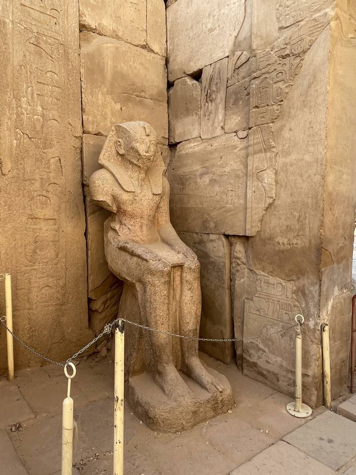 Statue leaning against a wall inside a temple.
