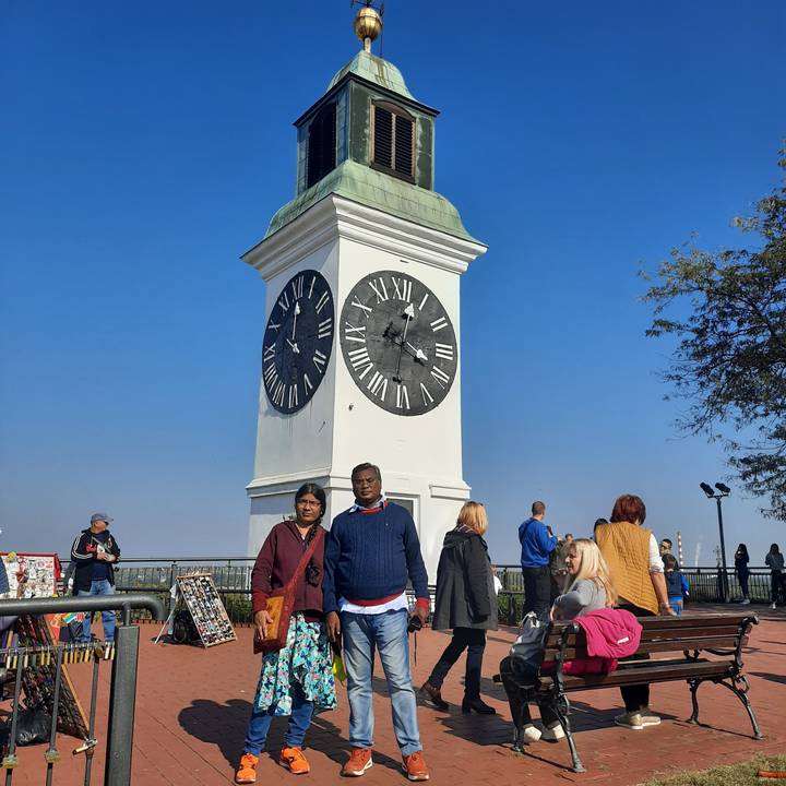 Uhrenturm mit Menschen davor.