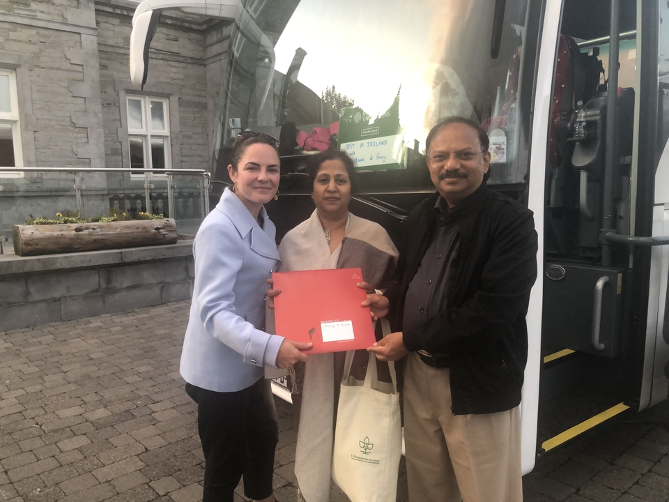 Groupe de personnes recevant un document à l'extérieur d'un bus.