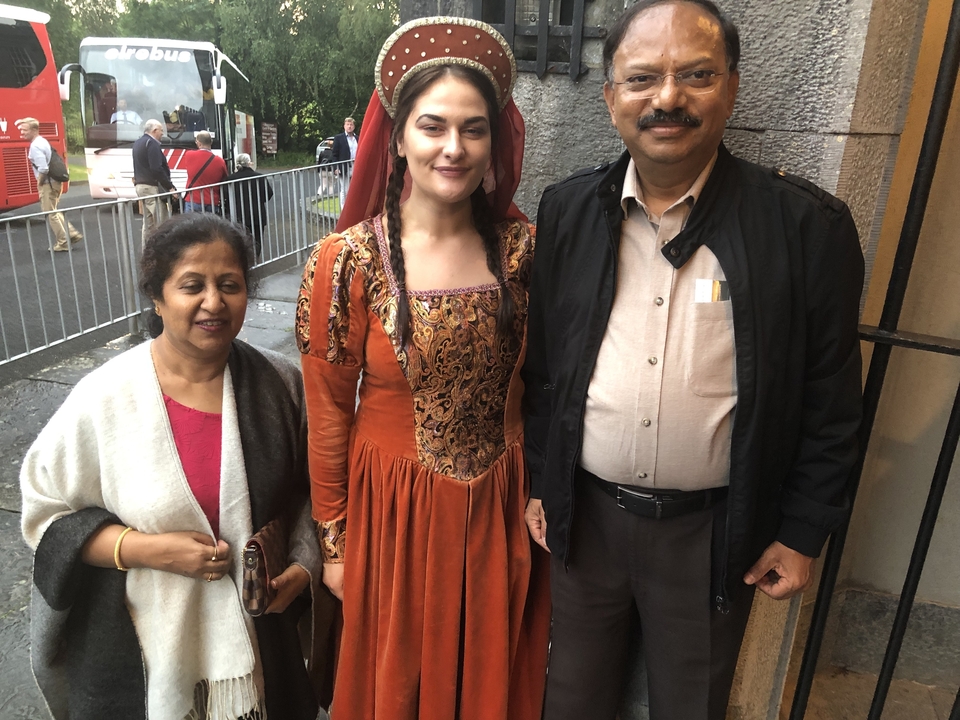 Deux personnes posant avec une femme en costume d'époque.